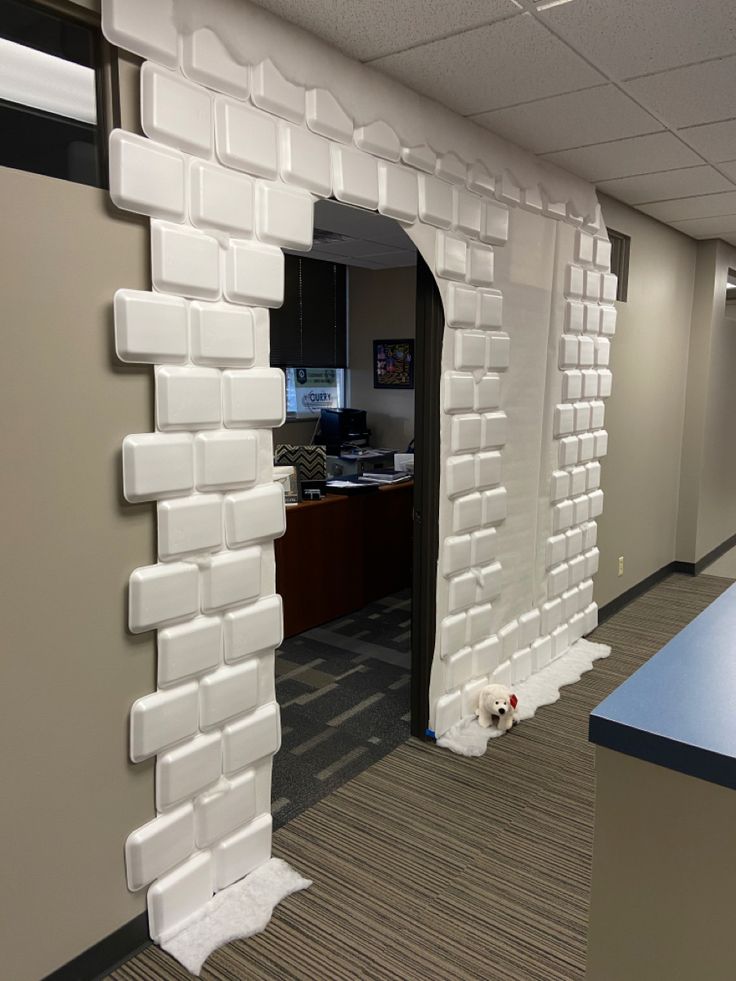 an office cubicle with a dog laying on the floor in front of it's door