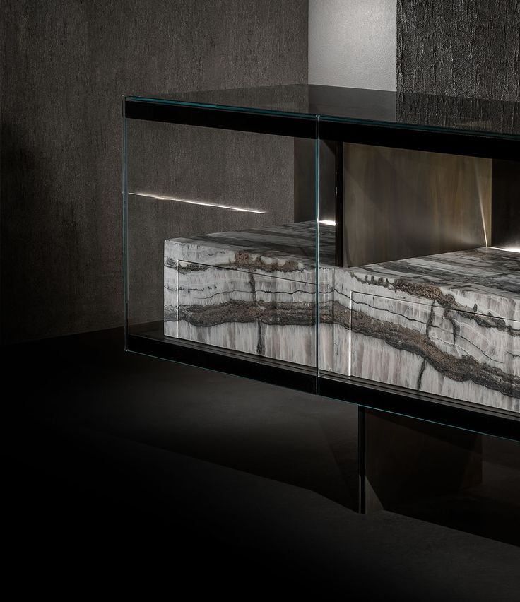 a glass display case with marbled material in the middle and black walls behind it