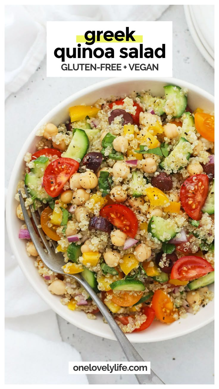 greek quinoa salad in a white bowl with a fork