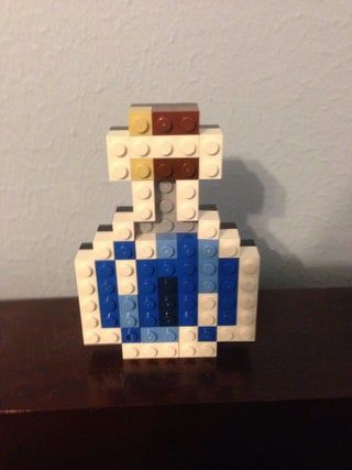 a toy made out of legos sitting on top of a wooden table next to a wall