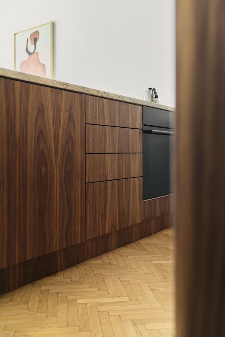 an empty kitchen with wood flooring and white walls