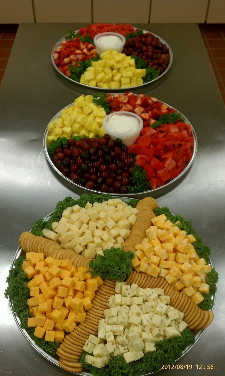 three trays filled with different types of cheese and crackers on top of each other