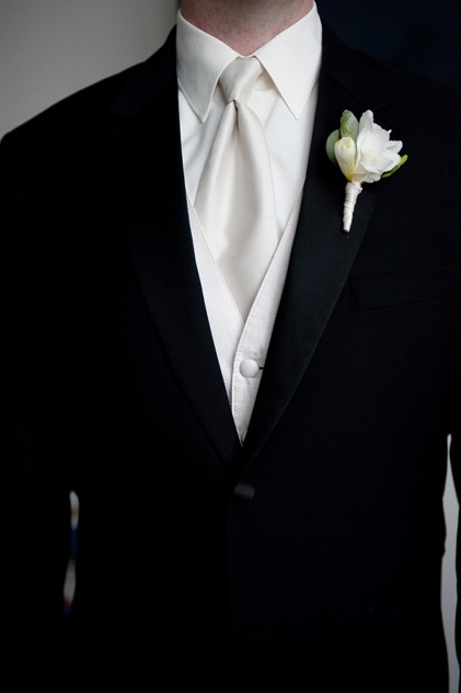 a man in a tuxedo with a boutonniere on his lapel