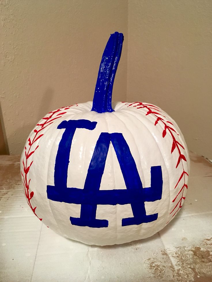 a painted baseball pumpkin with the word la on it's side, sitting on a table