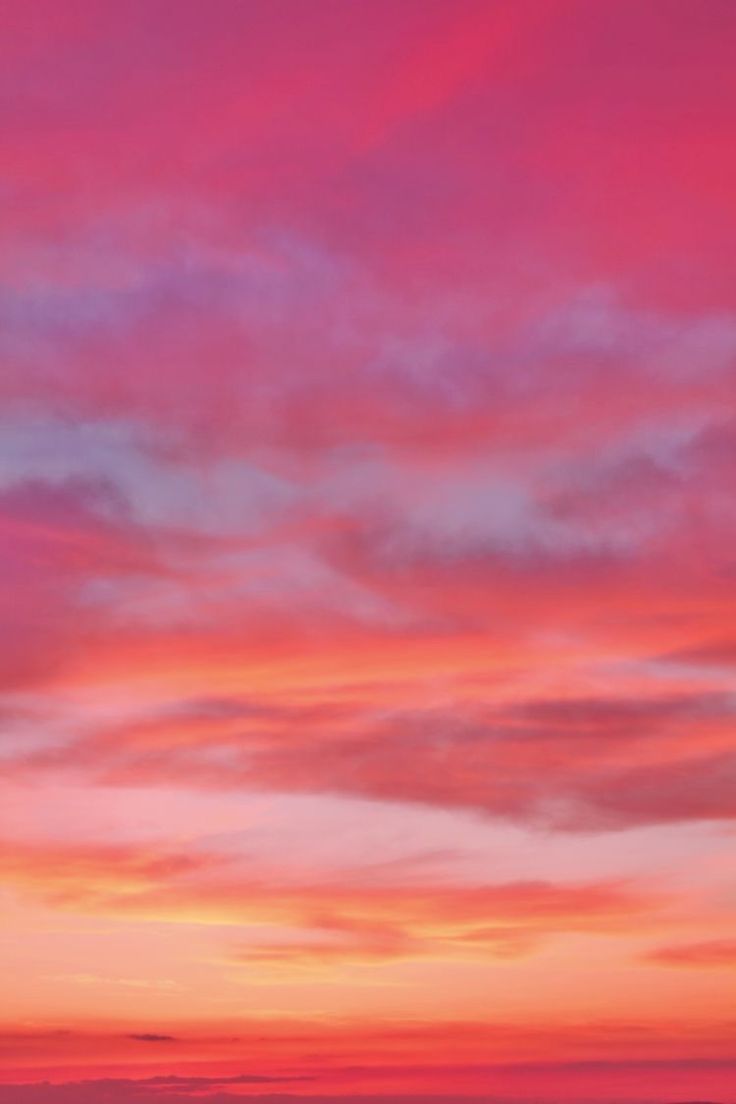 an airplane is flying in the sky at sunset or sunrise with pink and blue clouds