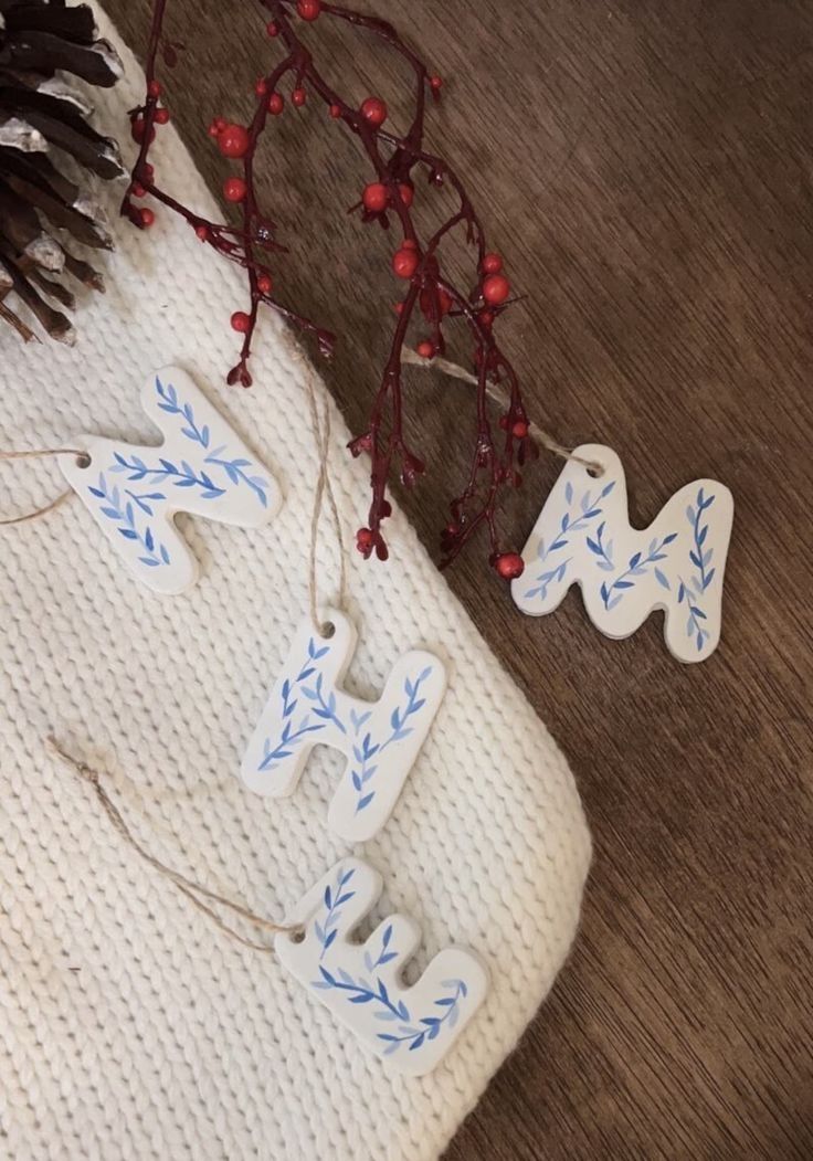 some ornaments are laying on the floor next to a pine cone and christmas tree branch