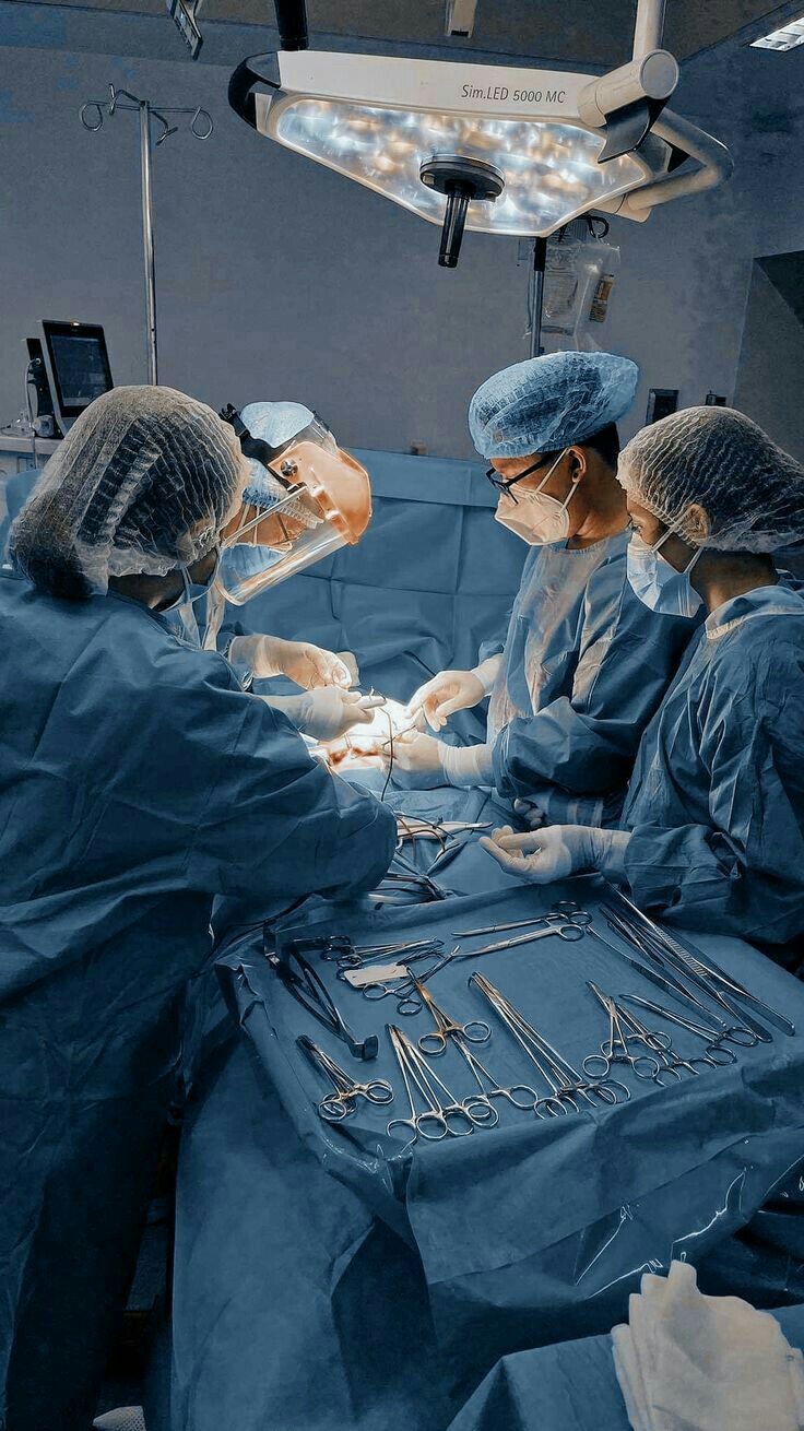 three surgeons performing surgery in an operating room