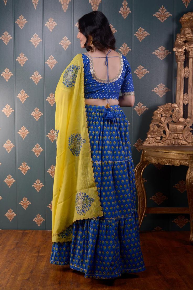 Royal blue tiered lehenga with floral block print motifs and gota patti trim on the hem. Comes with mirror embroidered blouse and lemon yellow floral print dupatta.
Component: 3
Pattern: Print and Embroidery
Type Of Work: Block Print and Mirror
Neckline: Round
Sleeve Type: Half
Fabric: Lehenga: Cotton Silk, Blouse: Banarasi Chanderi and Dupatta: Chanderi
Color: Blue
Other Details: 
Printed dupatta with scalloped border
Tie up with tassels on the side
Lace trim on the neckline and sleeve hems
Low Block Print Lehenga, Tiered Lehenga, Print Motifs, Floral Block Print, Blue Lehenga, Scalloped Border, Mirror Round, Printed Dupatta, Blue Block