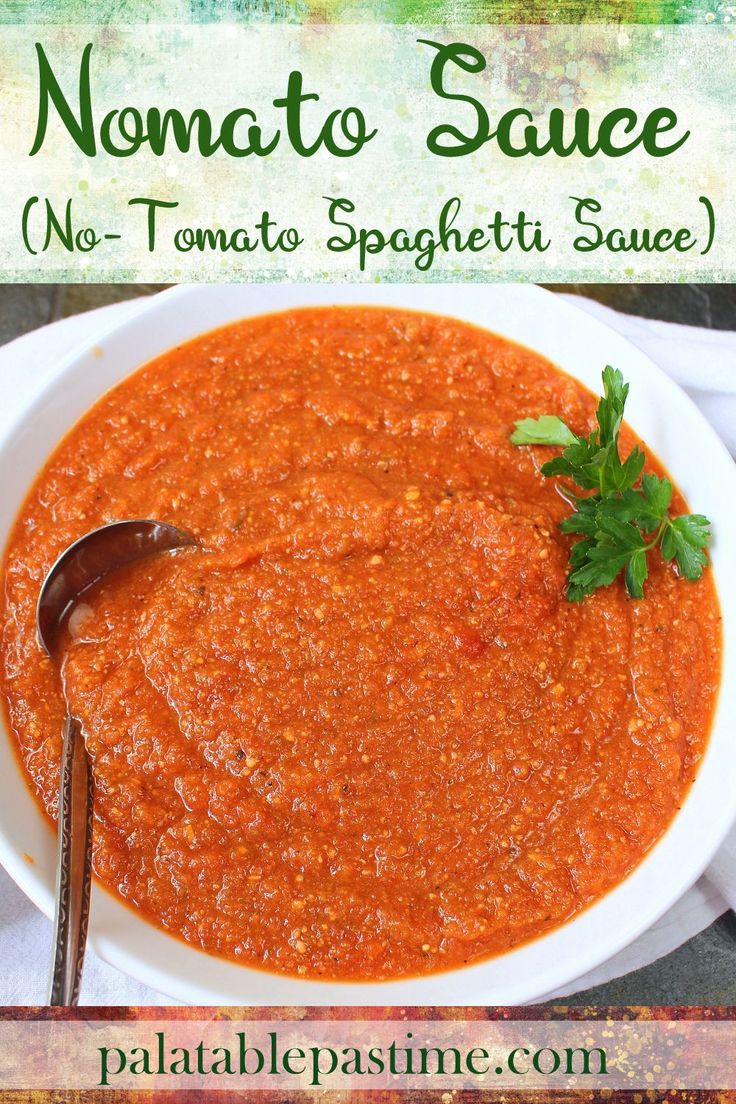 a white bowl filled with tomato sauce and garnished with parsley