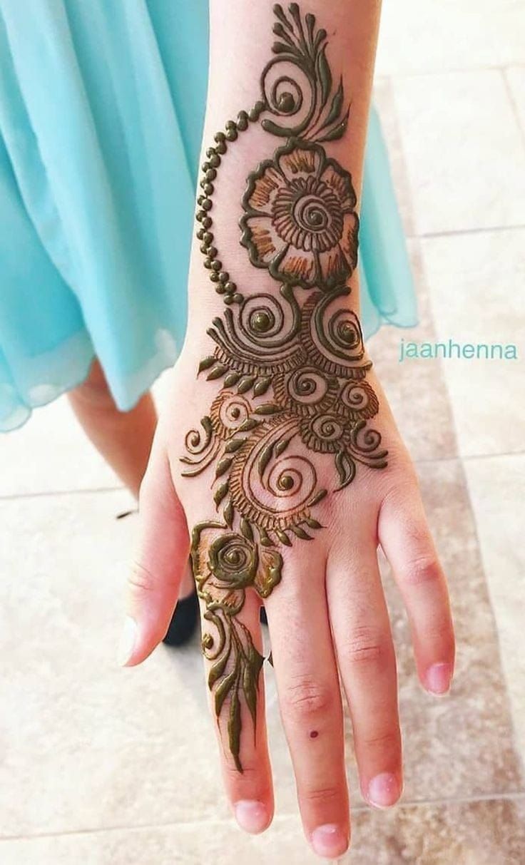 a woman's hand is decorated with henna designs on her left arm and wrist