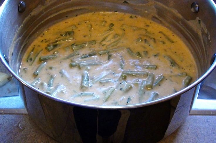 a pot filled with white sauce on top of a stove