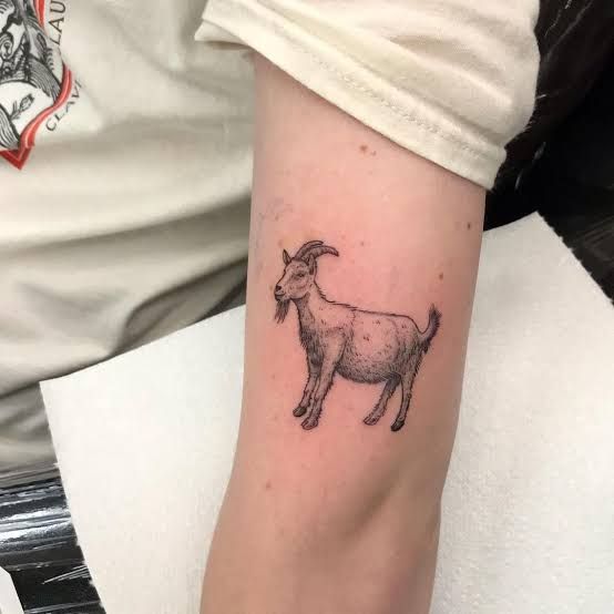 a small goat tattoo on the arm