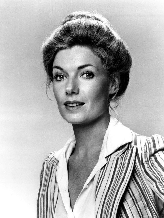 an old black and white photo of a woman wearing a striped shirt with her hair in a bun