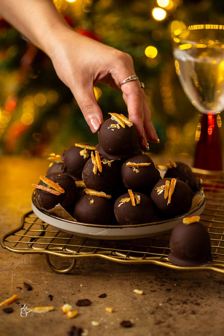 a person picking up some chocolates from a plate