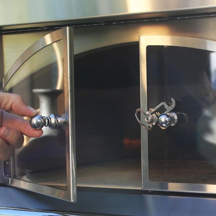 a close up of a person opening an oven door