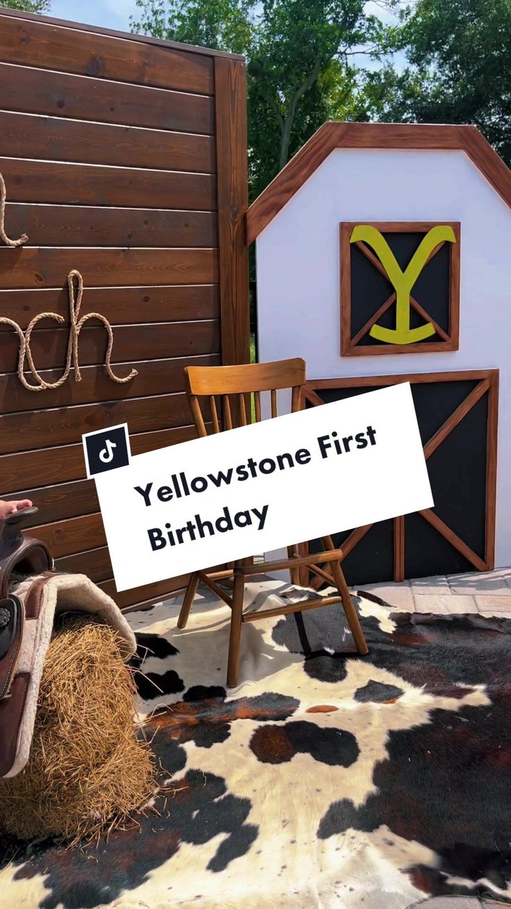 a sign that says yellow stone first birthday next to a chair and hay bale