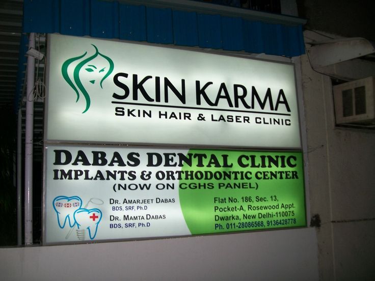 the sign for skin karma is lit up in front of a dentist's office