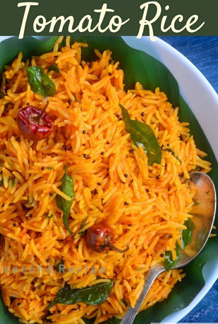 a white bowl filled with yellow rice and topped with green leafy garnish