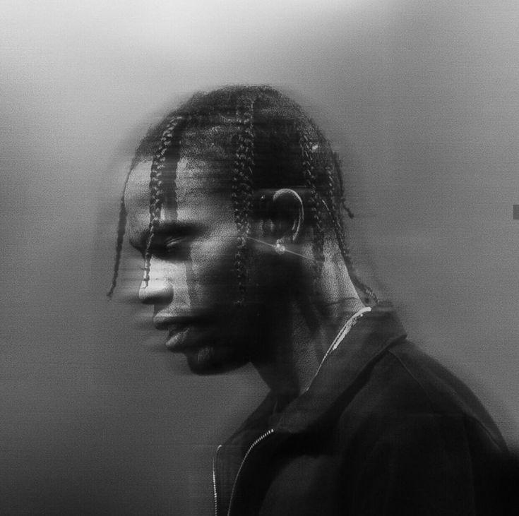 a black and white photo of a man with dreadlocks on his head, looking to the side