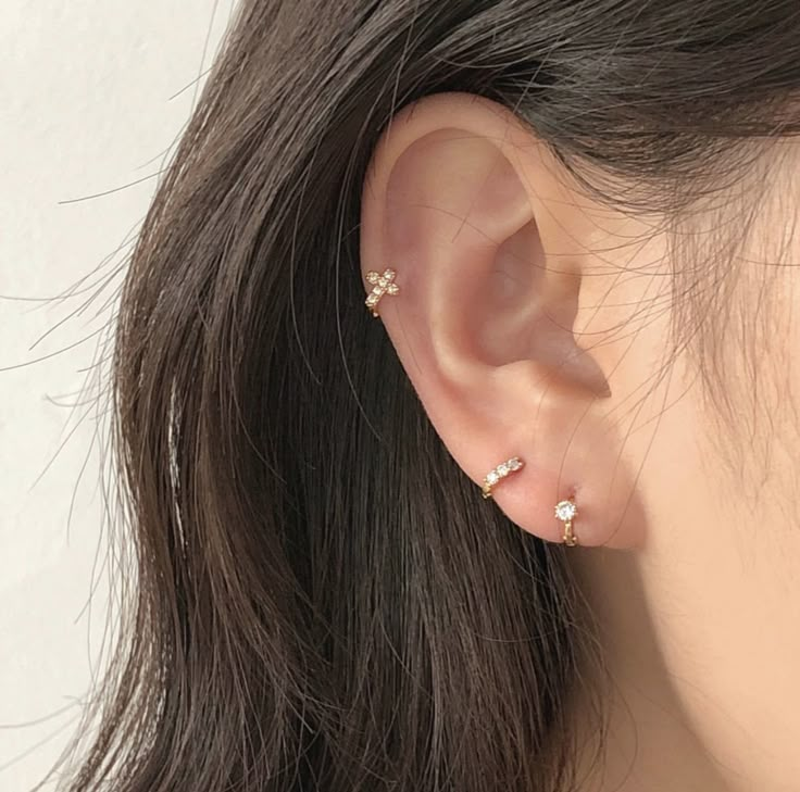 a close up of a person's ear with two small diamond studs on it