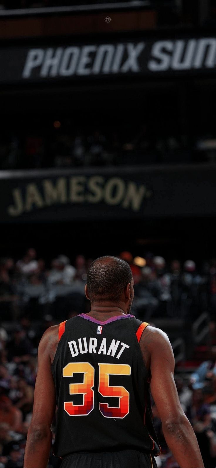 the back of a basketball player's jersey in front of an arena full of people