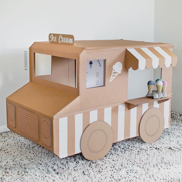 an ice cream truck made out of cardboard on the floor next to a white wall