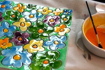 a bowl of orange juice next to a painting