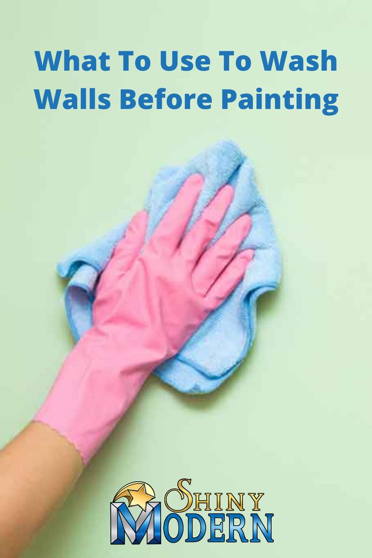 a person's hand with pink gloves on top of a blue and white wall