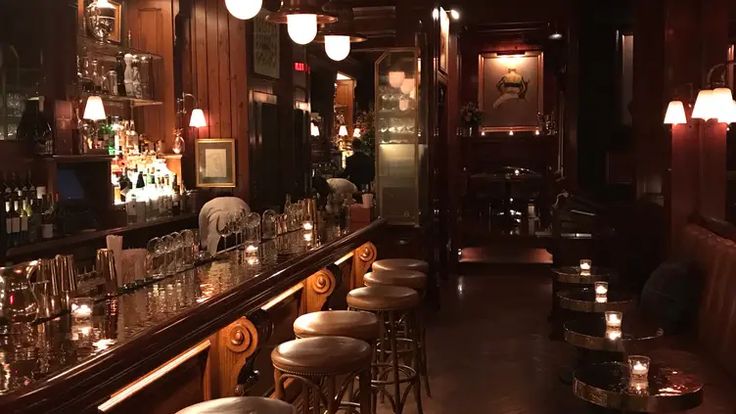 a dimly lit bar with candles on the counter