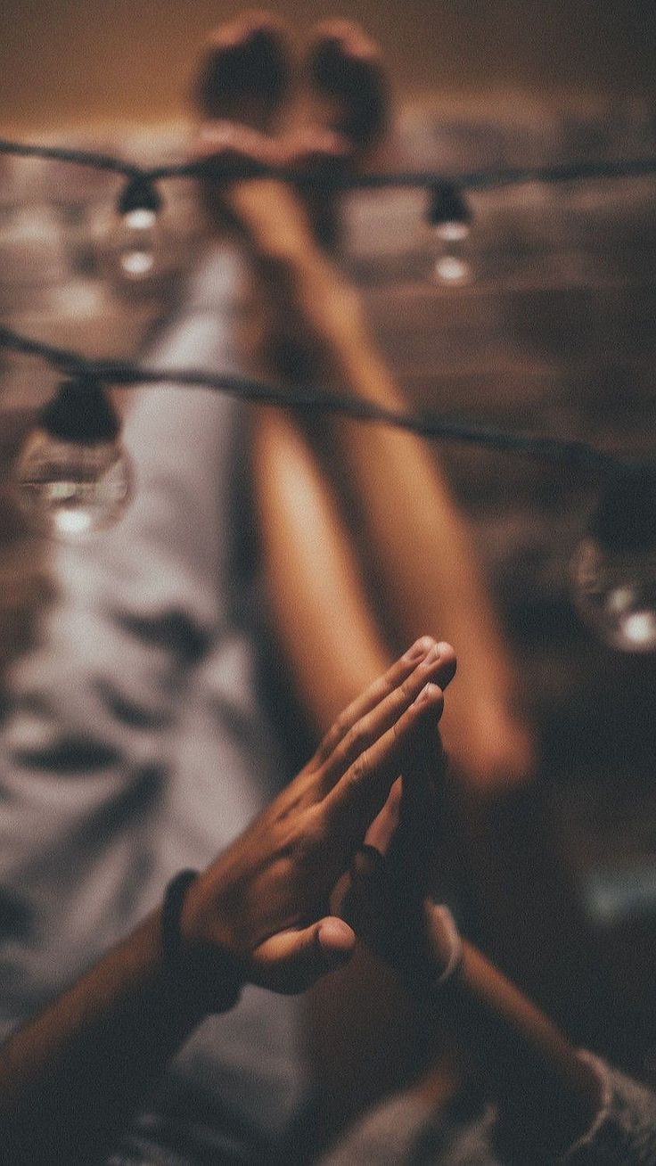 two people holding their hands together in front of some wires