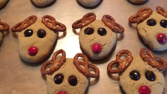 chocolate chip cookies decorated with reindeer noses and candy canes on a white paper towel