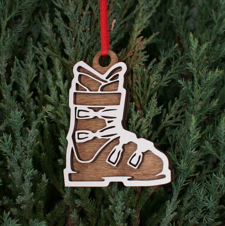 a wooden ornament hanging from a tree with a shoe on it's side