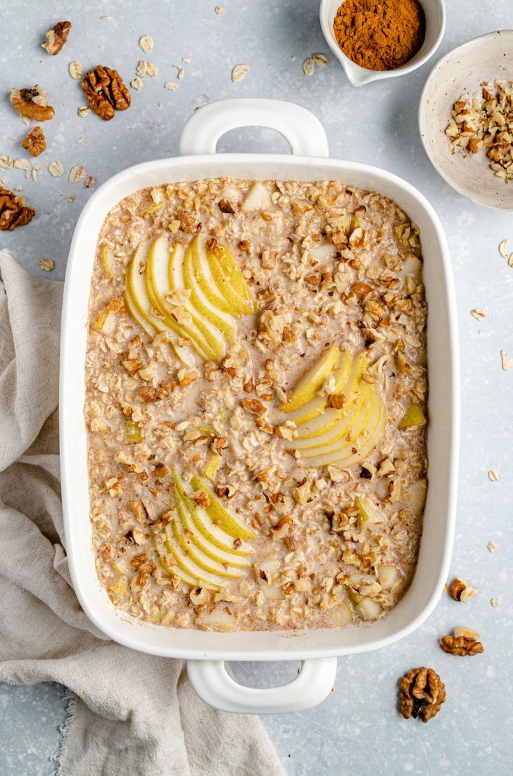 baked oatmeal with apples and walnuts in a white casserole dish