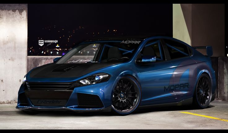 a blue car parked in a parking lot at night