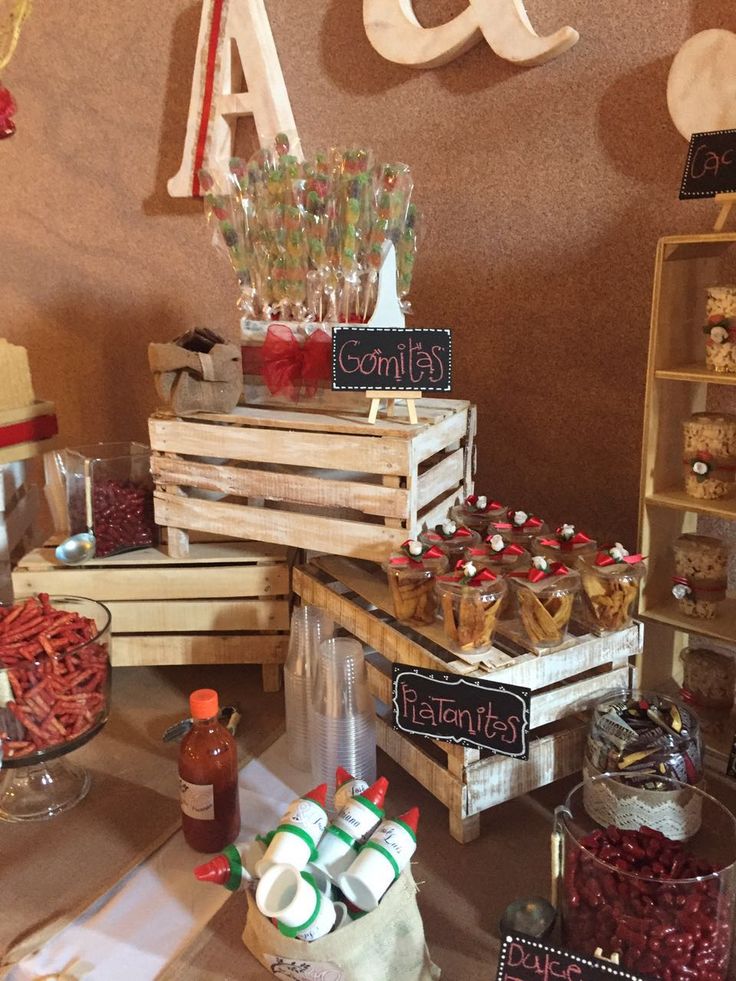 an assortment of desserts and candies on display at a party or event with wooden crates