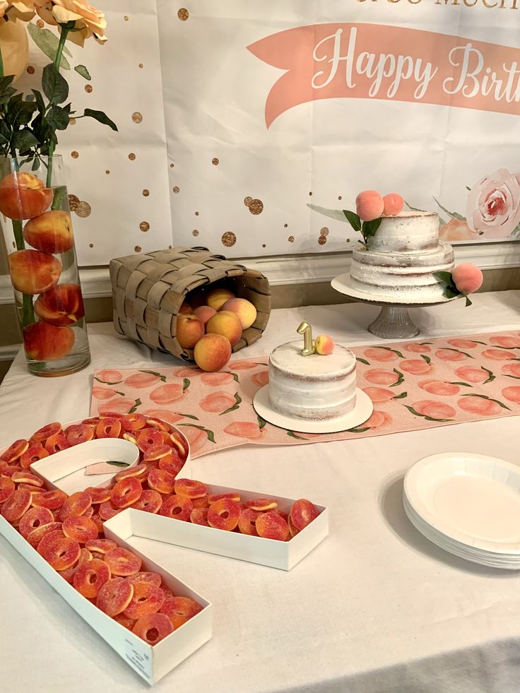 the table is set up with peaches and cake for two people to enjoy their birthday