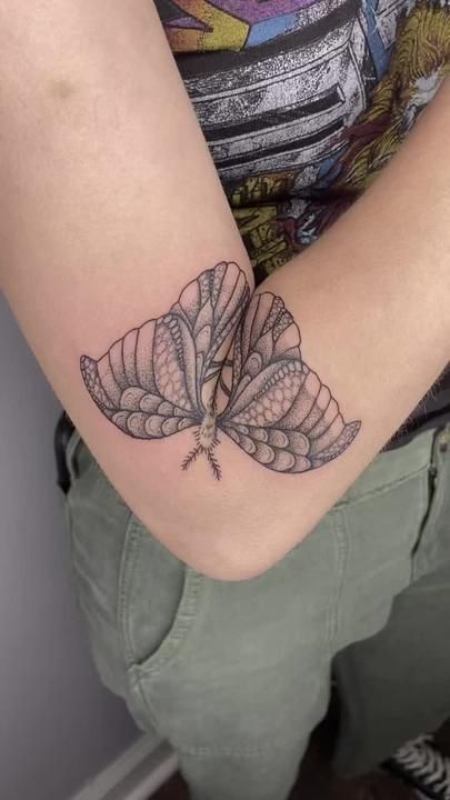 a woman's arm with a butterfly tattoo on the left side of her arm