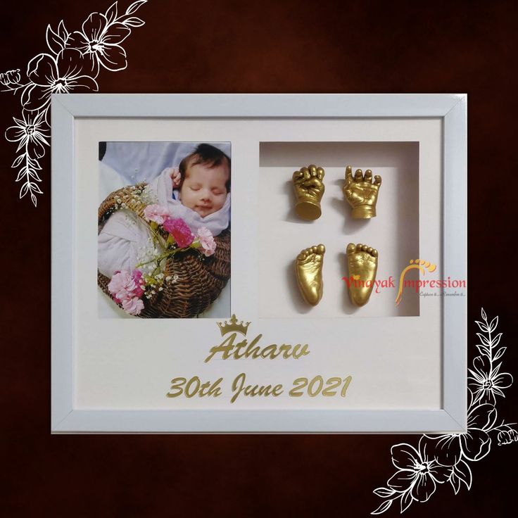 a baby's first year photo frame with three gold hand and foot casts in it