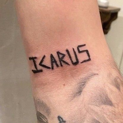 a wrist tattoo with the word karus on it