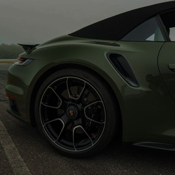 a green sports car is parked on the road