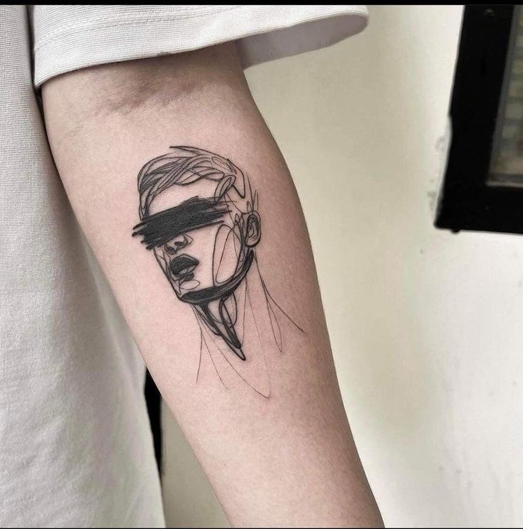 a woman's arm with a black and white tattoo design on the left forearm