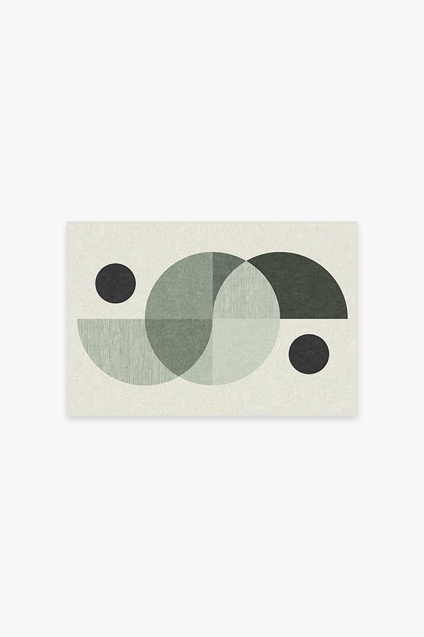 an abstract painting with black and green circles on white paper, against a gray background