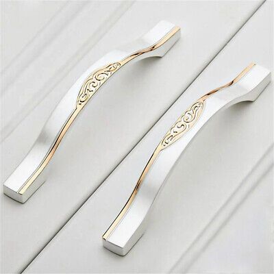 two white and gold toothbrushes sitting on top of each other