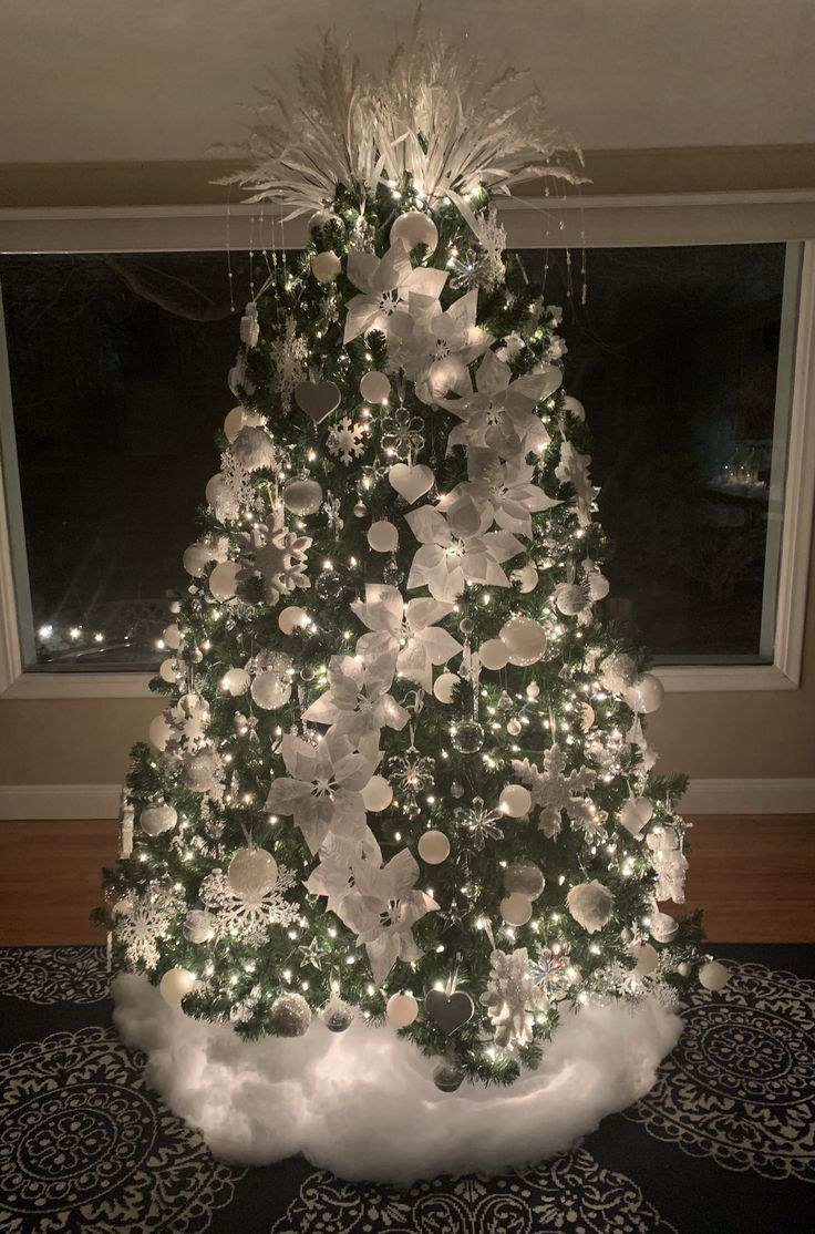 a white christmas tree with lights and ornaments