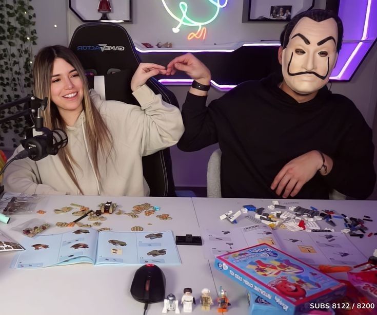 two people sitting at a table with masks on