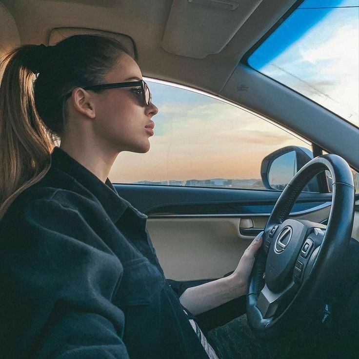 a woman sitting in the driver's seat of a car