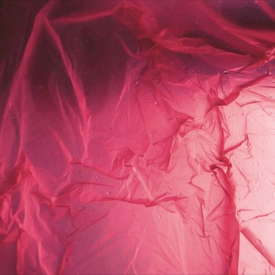 the fabric is covered with water droplets and pink light from above it, as if in an underwater world