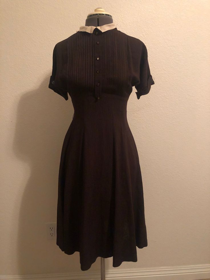 "1940's brown pinstripe wool dress. Empire seam then Fitted at the waist and more full through the hips and hems. Pleated details at the bust with front button placket. All buttons accounted for, but most are missing their center stones. Short sleeves in kimono style with cuff and button. Small linen collar. Original metal Center back zip  Neck 14.5\" Shoulders 16\"? (No seam, kimono sleeve)  Bust 34\"  Sleeve hem circumference 11\" Waist 26.5\"  Hips 42\" Cb length 40\"" Pin Stripe Dress, Brown Pinstripe, Vintage Gloves, Pinstripe Dress, Pin Stripe, Kimono Style, Stripe Dress, Kimono Sleeve, Wool Dress