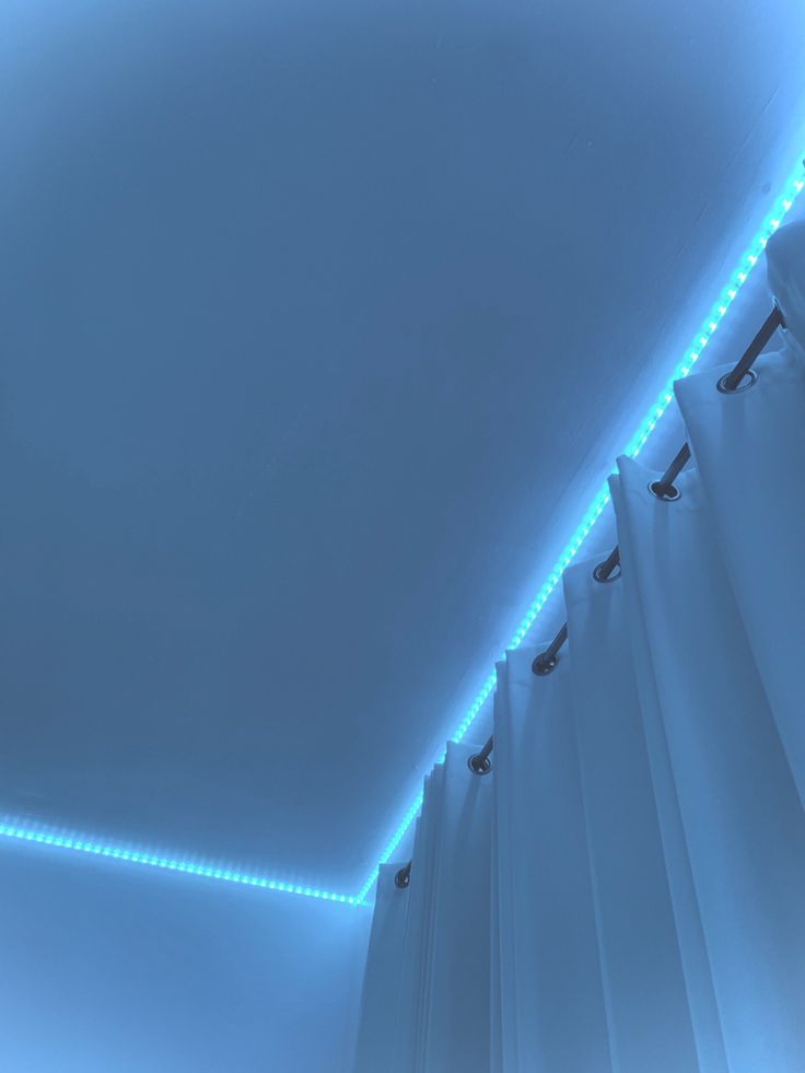 an empty room with blue lights on the ceiling