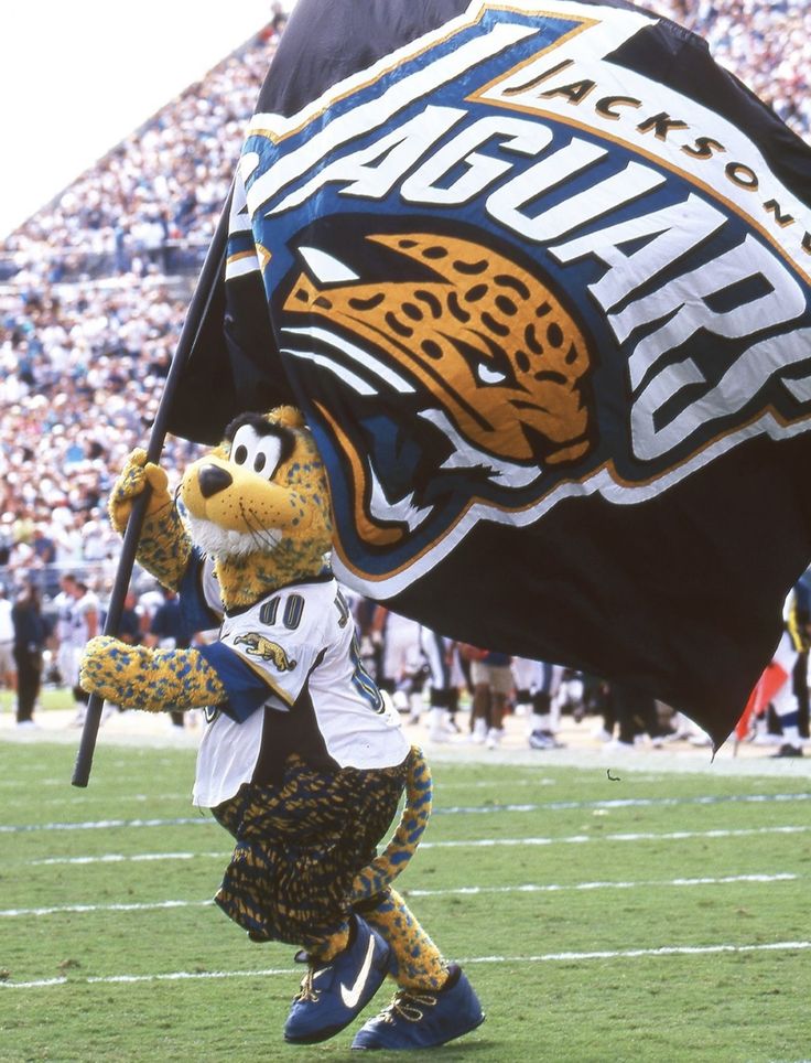 the jacksonville tigers mascot is on the football field and holding a flag in his hand